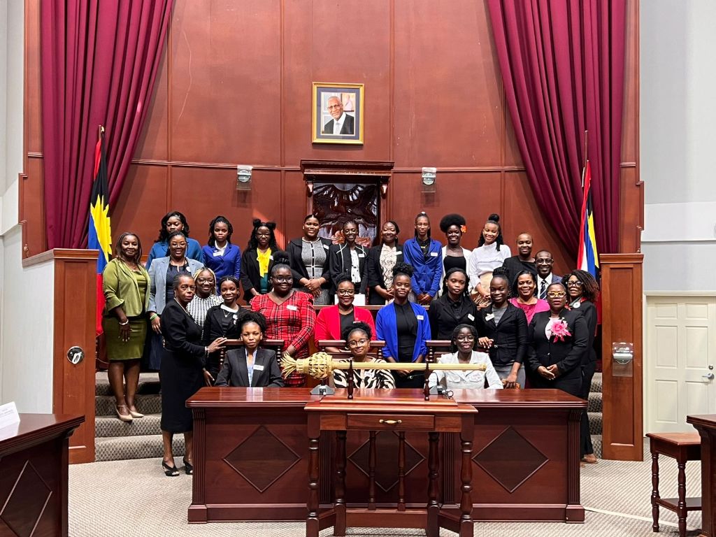 Full group photo of YWiL AB 2026 cohort and CIWiL AB leaders inside the Antigua and Barbuda Parliament chamber